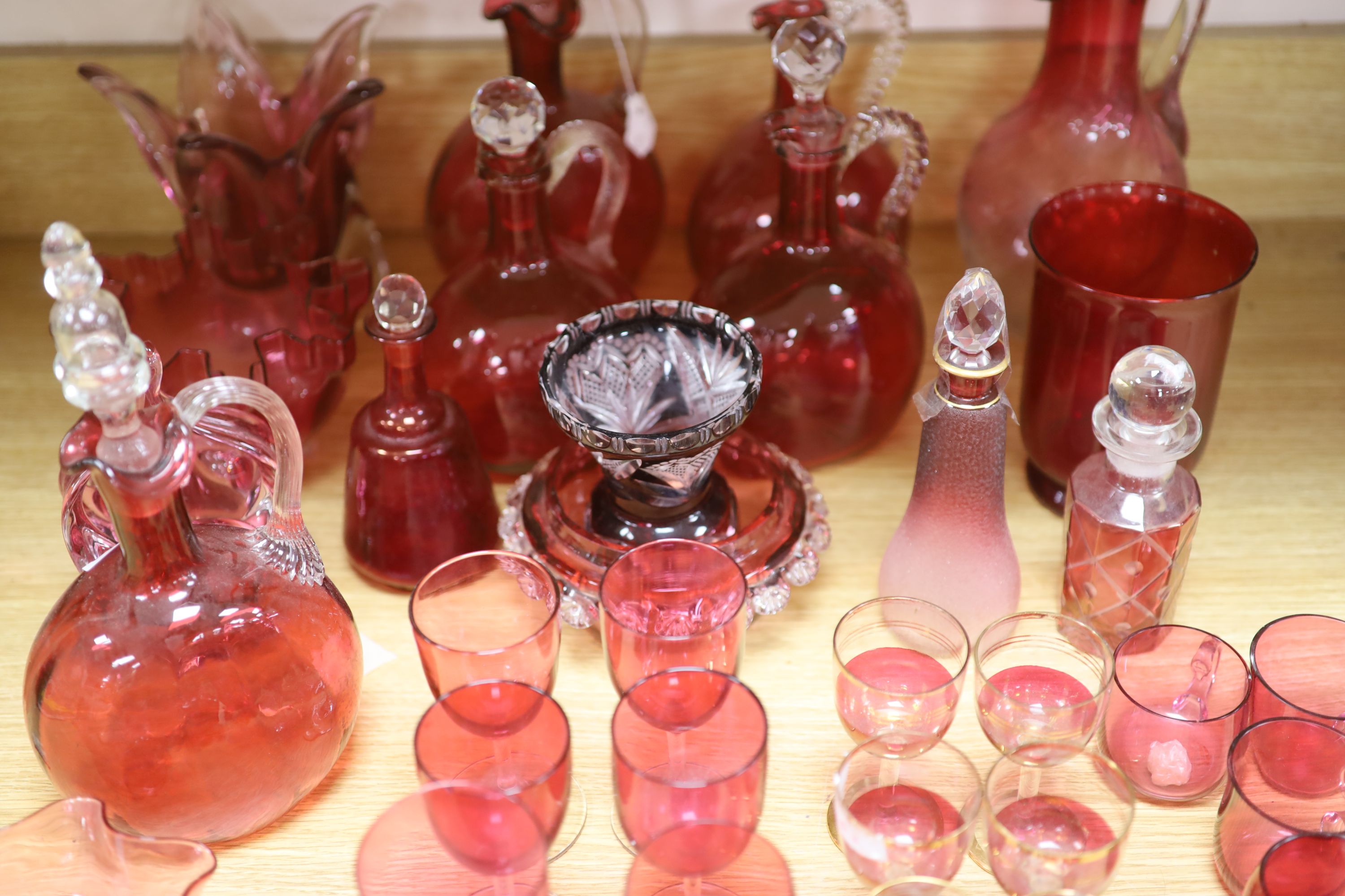 A large collection of cranberry glass